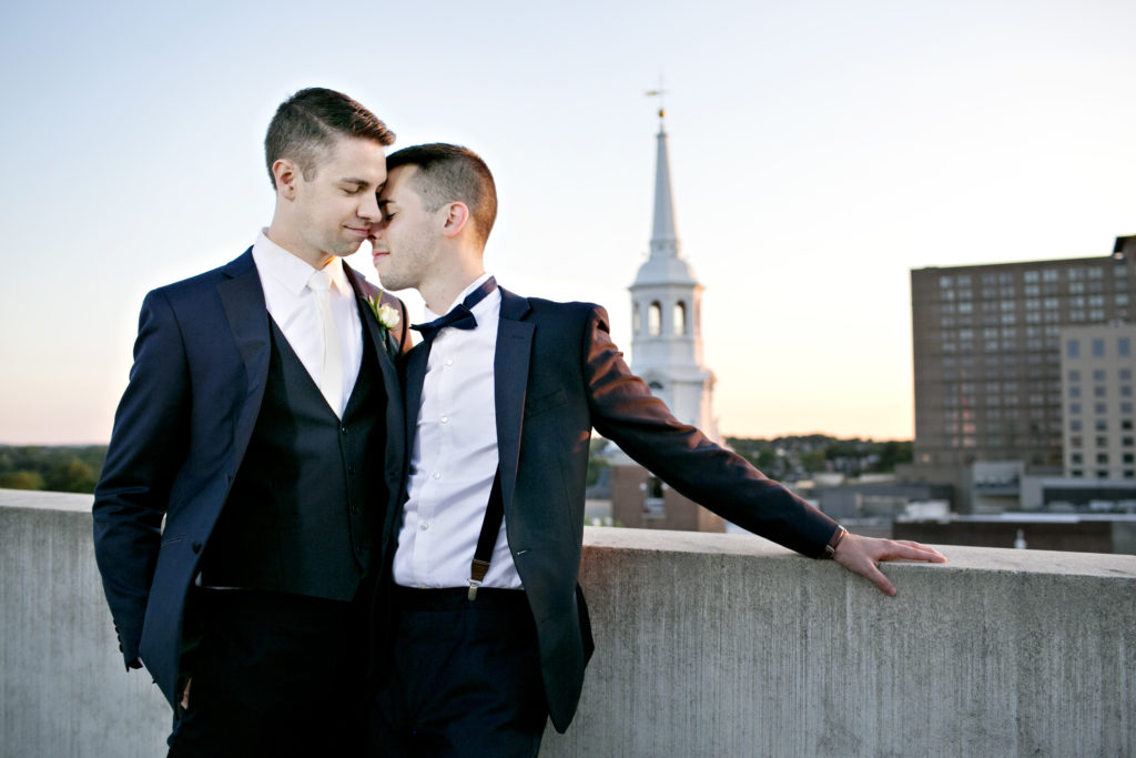 Two grooms on a roof at sunset